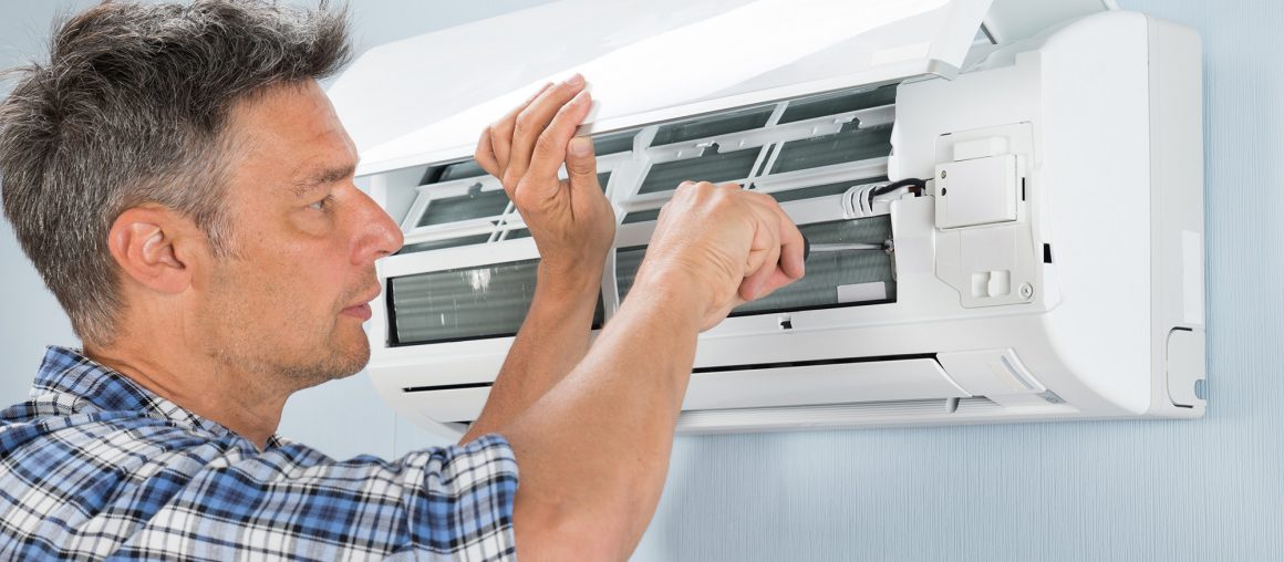 Portrait Of Mid-adult Male Technician Repairing Air Conditioner